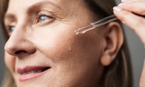 close-up-smiley-senior-woman-using-serum-scaled